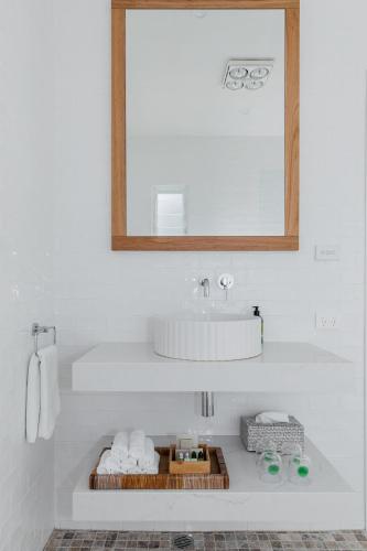 a bathroom with a sink and a mirror and towels at Bay Cottage in Patonga Beach