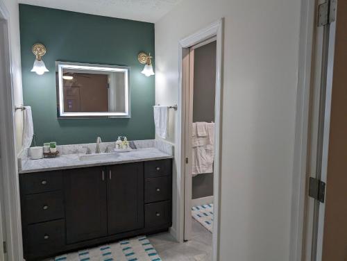 a bathroom with a sink and a mirror at Modern Luxe Family & Groups Friendly Bungalow with Patio & Workspace in Marietta