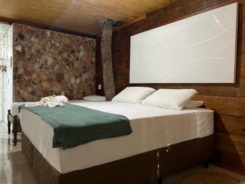 a bedroom with a large bed with a large screen at Pousada Coral Negro in Jericoacoara