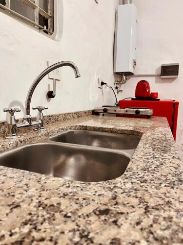 um lavatório numa cozinha com um balcão de granito em Depto em San Francisco