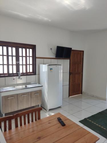 uma cozinha com um frigorífico branco e uma mesa de madeira em Mazz_q_casa em Ilhabela