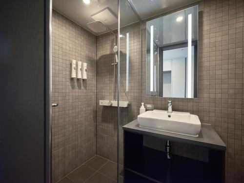 La salle de bains est pourvue d'un lavabo et d'un miroir. dans l'établissement Y Collection by UH FLAT Haeundae beach, à Busan