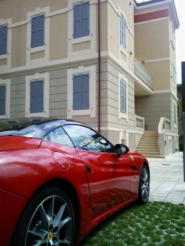 a red car parked in front of a house at Hotel Villa Maranello in Maranello