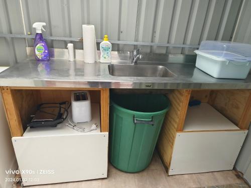una encimera con fregadero y cubo de basura en Private Large double room, en Auckland