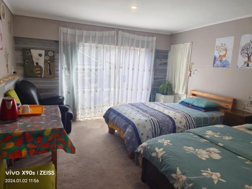 1 dormitorio con 2 camas, silla y ventana en Private Large double room, en Auckland