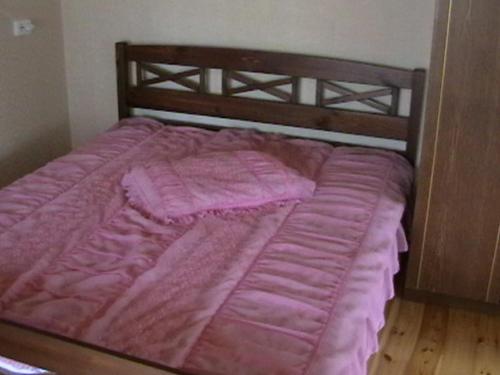 a pink bed with a wooden frame in a bedroom at Paide Homestay in Kriilevälja