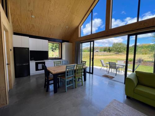 a kitchen and dining room with a table and chairs at Mill Creek Cottage in Arrowtown