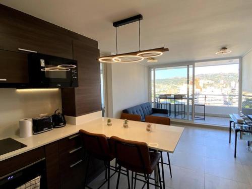 a kitchen and living room with a table and chairs at Hermoso departamento 2 dormitorios +2 baños, nuevo, ubicación perfecta in Viña del Mar