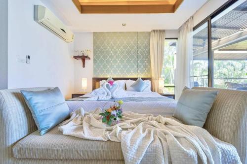 a bedroom with a bed and a couch with a blanket at 3 Bed Luxury Bali Style Villa Close To Beach PR6 in Ban Bo Kaeo