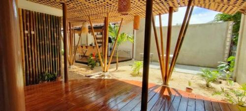 ein Wohnzimmer mit Holzboden und Sonnenschirm in der Unterkunft Intoy's Place in Panglao