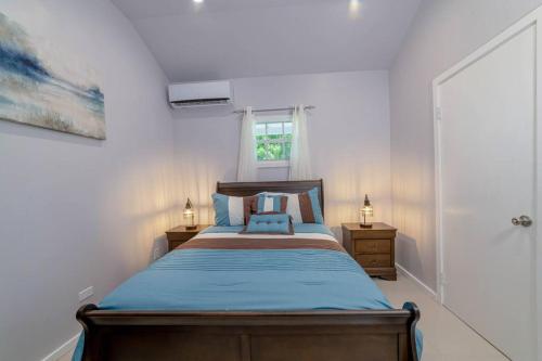 a bedroom with a bed with blue sheets and a window at Cozy Corner (Mercy's Place) in Buckleys