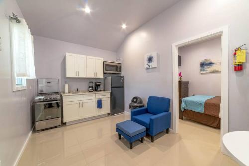 une petite cuisine avec une chaise bleue et une chambre dans l'établissement Cozy Corner (Mercy's Place), à Buckleys