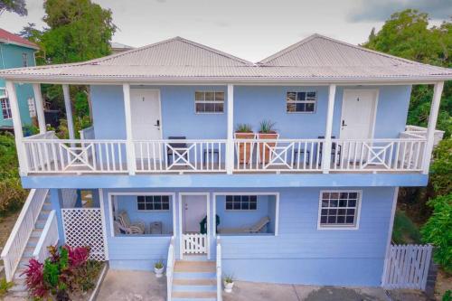 a large blue house with a white balcony at Cozy Corner (Mercy's Place) in Buckleys