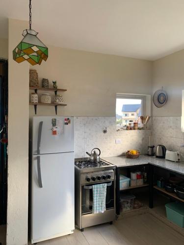 Il comprend une cuisine équipée d'un réfrigérateur blanc et d'une cuisinière. dans l'établissement CUNCUMEN Caviahue, à Caviahue
