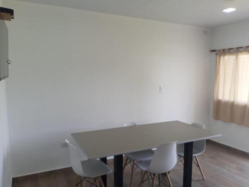 una mesa y sillas blancas en una habitación con ventana en Complejo - LA ZULA - en Federación