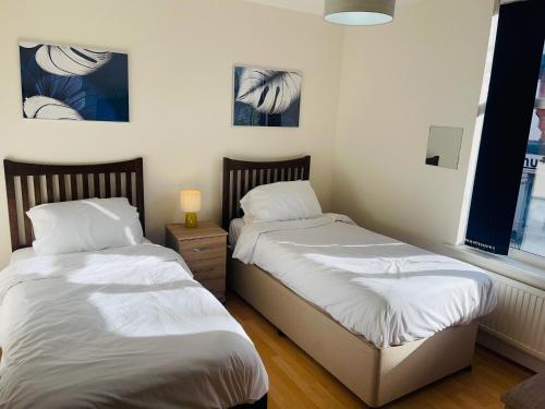 two beds sitting next to each other in a bedroom at Baravaggio By Kasar Stays in Leicester