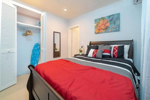 1 dormitorio con 1 cama con manta roja en Hibiscus Cottage (Mercy's Place) en Buckleys