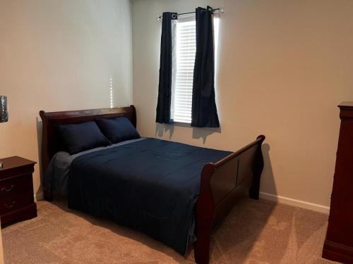 - une chambre avec un lit doté d'un couvre-lit bleu et d'une fenêtre dans l'établissement Home Away From Home, à Richmond Hill