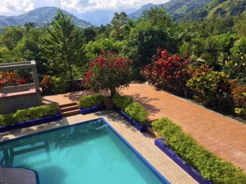 a swimming pool in a garden with mountains in the background at Nature villa Bonao in Bonao