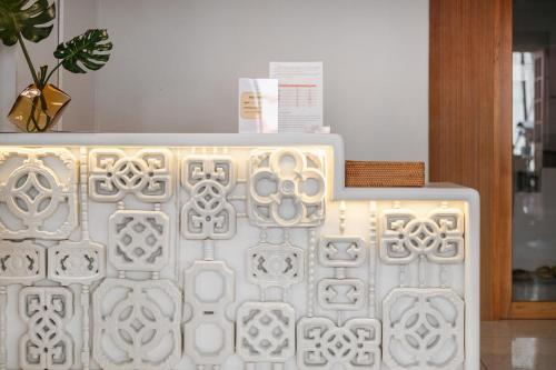 a white wall with a pattern on it at Unplugged at Bangrak Design Hostel in Bangkok