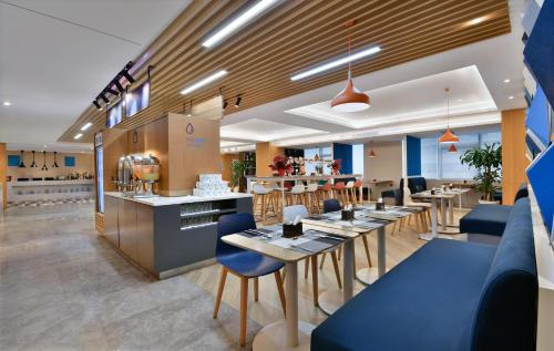 a restaurant with tables and chairs and a counter at Holiday Inn Express Chengdu North Railway Station, an IHG Hotel in Chengdu