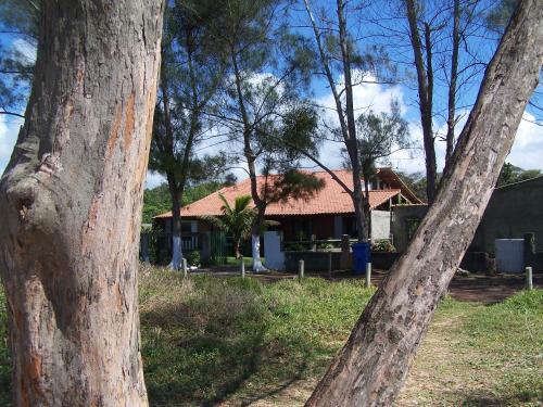 una casa in mezzo a un gruppo di alberi di Casa de seis suites na beira do mar a Rio das Ostras