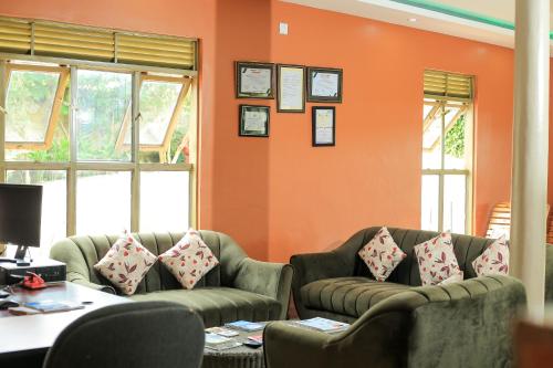 una oficina con dos sillas y una pared naranja en Triple Tee Gardens & Accomodation, en Wakiso