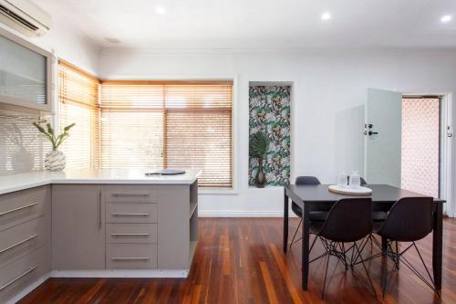 Una cocina con una mesa y sillas en una habitación. en Cosy Cottage Coolbellup, en Spearwood