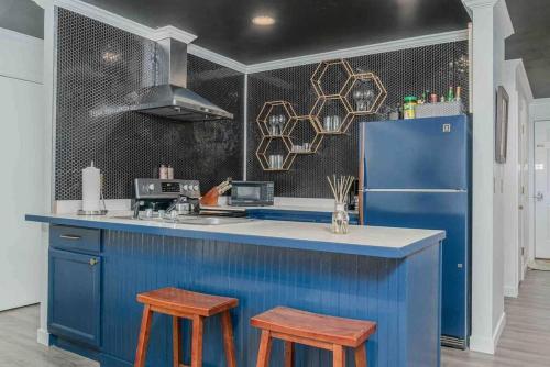 a blue kitchen with two stools and a refrigerator at Designer Unit -Center of Town of Telluride, steps to Gondola and town park in Telluride