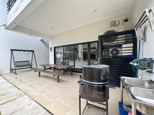 a kitchen with a table and a bench and a table at Roxy Sematan Beach Townhouse Deluxe , 1 & 2 in Sematan