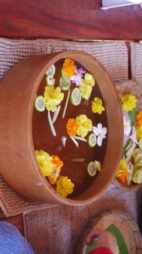 a wooden bowl with flowers on top of it at Imsuk Bo Klua in Ban Pha Khap
