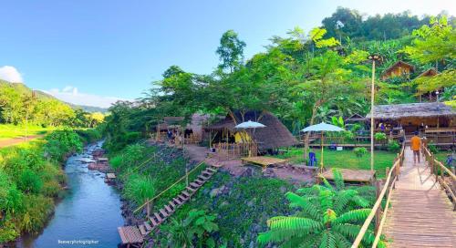 a river next to a resort with a bridge at Imsuk Bo Klua in Ban Pha Khap