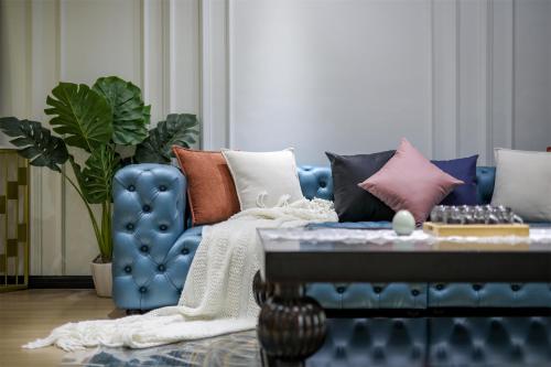 a blue couch with pillows on it in a living room at Baihong Riverview Apartment-Hongya Cave in Chongqing