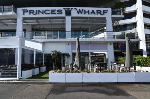 a building with umbrellas and flowers in front of it at Luxurious & Spacious Living with Breathtaking Views in Auckland