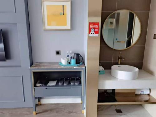 een badkamer met een wastafel en een spiegel bij Lano Hotel Guizhou Zunyi High Speed â€‹â€‹Railway Station Medi City in Zunyi