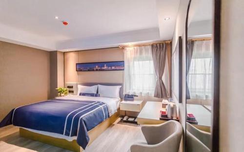 a hotel room with a bed and a chair at LanOu Hotel Zhengzhou High-Tech Zone Headquarter Enterprise Base in Zhengzhou