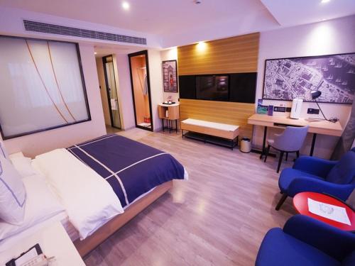a hotel room with a bed and a desk and chairs at Lano Hotel Guizhou Zunyi Renhuai Power Supply Bureau Office Building in Zunyi
