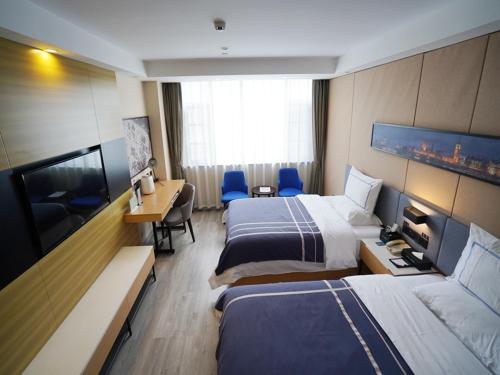 a hotel room with two beds and a desk at Lano Hotel Guizhou Zunyi Renhuai Power Supply Bureau Office Building in Zunyi