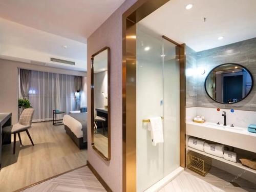 bagno con lavandino e specchio di Lano Hotel Guiyang High Speed Rail North Station Dream City a Guiyang