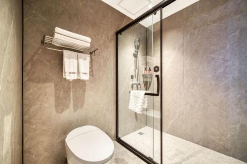 ein Bad mit einem WC und einer Glasdusche in der Unterkunft Thank Inn Chain Hotel Jiangsu Changshu Meili Town Meili in Xuxiang