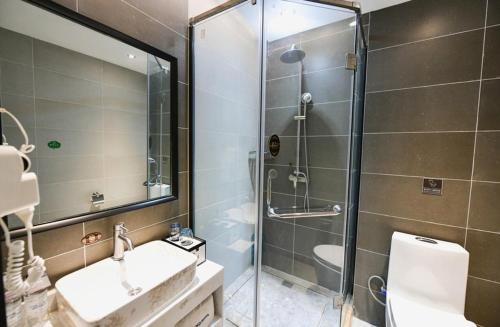W łazience znajduje się prysznic, toaleta i umywalka. w obiekcie LanOu Hotel Zhengzhou High-Tech Zone Headquarter Enterprise Base w mieście Zhengzhou