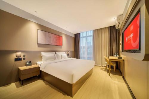 ein Hotelzimmer mit einem großen Bett und einem TV in der Unterkunft Thank Inn Chain Hotel Jiangsu Changshu Meili Town Meili in Xuxiang