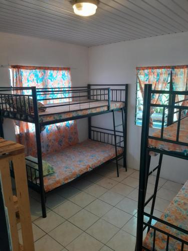 um quarto com 2 beliches e 2 janelas em Ravehei smile papeete punaauia em Papeete
