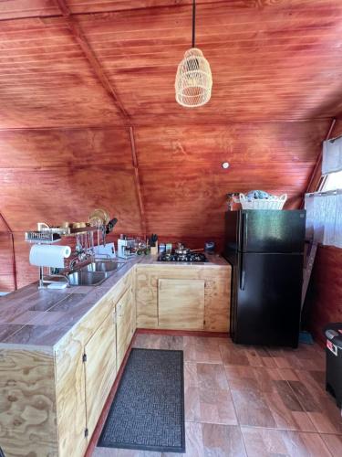 a kitchen with a sink and a refrigerator at Cabaña 787 in Lares