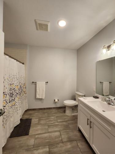 a bathroom with a toilet and a sink at Stylish Modern 2BR Mins to NYC! in Jersey City