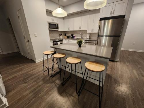 a kitchen with a large island with bar stools at Stylish Modern 2BR Mins to NYC! in Jersey City