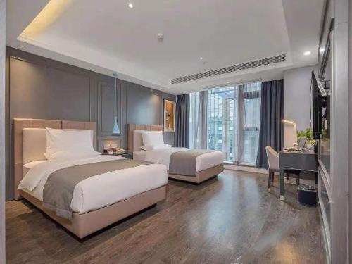 Habitación de hotel con 2 camas y escritorio en Lano Hotel Guizhou Zunyi Xinpu New District Linda Sunshine City, en Zunyi