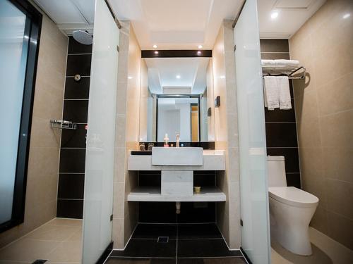 uma casa de banho com um lavatório e um WC em LanOu Hotel Yellowstone Harbor Area Moore Cityland em Huangshi