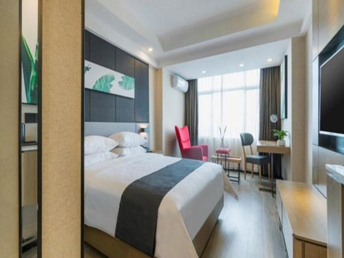 ein Hotelzimmer mit einem großen Bett und einem Schreibtisch in der Unterkunft Thank Inn Chain Hotel Chongqing Wuxi County Shuangzitian Street in Wuxi