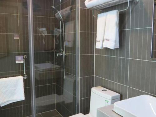 ein Bad mit einer Glasdusche und einem WC in der Unterkunft Thank Inn Chain Hotel Shangrao Houjiagang Poyang 